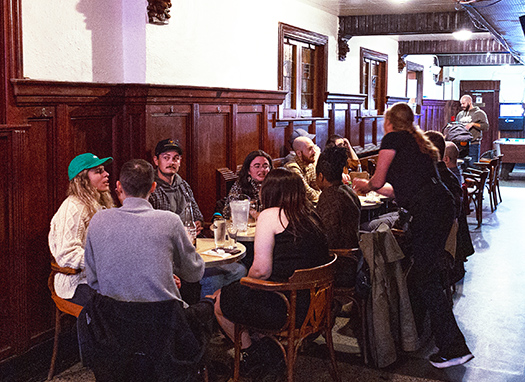 A group of people at a table being waited upon by a waitress.